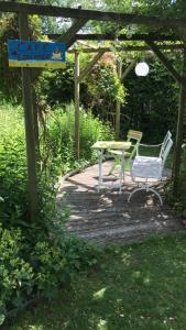 a table and chairs sitting under a pergola at gemütliches Gästezimmer in Ostseenähe in Stubbendorf +6 photos