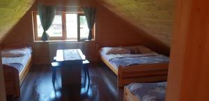 a attic room with two beds and a table at Chochołowsko-Witowski Wypoczynek in Witów