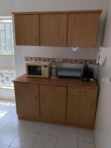 a kitchen with a microwave on top of a counter at Swiss Garden House in Kerr Sering With Full Private Compound in Amdalai