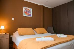 1 dormitorio con 1 cama con 2 toallas en Aparthotel Don Alonso, en Antofagasta