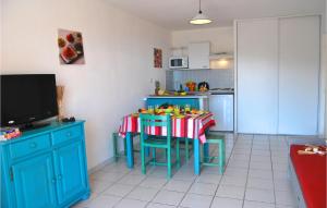 uma cozinha com uma mesa e uma cozinha com um armário azul em Le Village Des Aloes em Cerbère