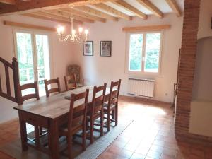 Belle maison proche de la ville et du lac في Belcaire: غرفة طعام مع طاولة وكراسي خشبية