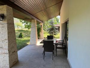 patio con tavolo e sedie sotto un soffitto in legno di Casa Rafael a Sighetu Marmaţiei