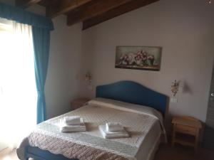 ein Schlafzimmer mit einem blauen Bett und Handtüchern darauf in der Unterkunft Rosa dei Venti in Provaglio d'Iseo
