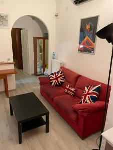 una sala de estar con un sofá rojo con almohadas británicas en Milano Central Station, en Milán