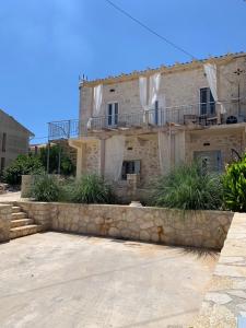 a large stone house with a stone wall at Dizen Spartochori in Meganisi