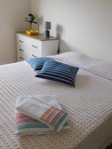 a bedroom with a bed with two pillows and a dresser at NiaAzoreanApartments2, aconchegante e confortável! in Horta