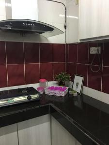 a kitchen with a black counter top with a stove at Homestay Teratak Saazlina in Seremban