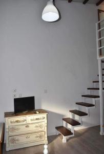 una camera con cassettiera e scale accanto a un muro di Loft Kapodistrias a Città di Corfù