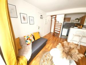a living room with a couch and a kitchen at Le cocoon Hyper centre Orleans proche Gare in Orléans
