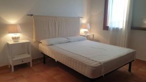 una camera con un grande letto con due lampade di Capo Figari 15, appartamenti a Golfo Aranci a Golfo Aranci