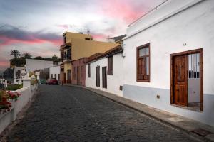 a cobblestone street in a town with a cloudy sky at Casita tradicional canaria en Garachico - SanRoquito18 in Garachico