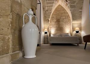 a large white vase sitting in a room with a bed at Ai Propilei del Duomo Luxury Suite in Lecce