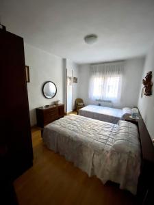 een slaapkamer met 2 bedden en een raam bij APARTAMENTO CENTRO BURGOS in Burgos