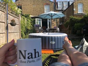 una persona tumbada en un banco con una taza de café en Wimbledon fortnight, en Londres