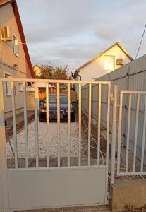 a fence with a car parked in a driveway at Marcell Apartman in Hajdúszoboszló