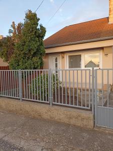 a fence in front of a house at Marcell Apartman in Hajdúszoboszló