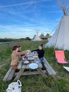 een groep mensen die rond een picknicktafel zitten bij Terra-Tipike, Entre Terre et Mer in Trébry