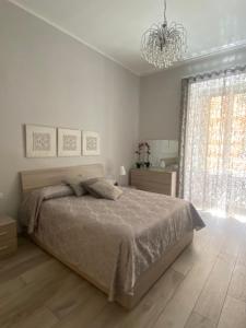 um quarto branco com uma cama e um lustre em Dea Suite em Nápoles