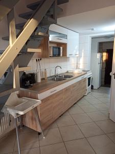 a kitchen with wooden cabinets and a sink at Marcell Apartman in Hajdúszoboszló