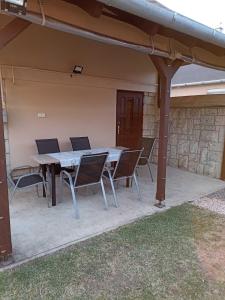 a patio with a table and chairs under a pergola at Marcell Apartman in Hajdúszoboszló
