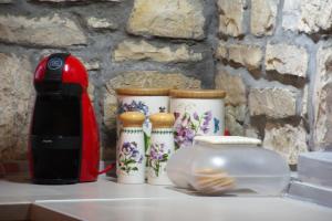 a counter with four cups and a toaster on it at Epirus Stone Suites in Elaía