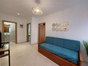 a living room with a blue couch in a room at Encosta do Sol Apartamentos in Albufeira