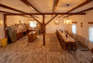 a dining room with wooden tables and a kitchen at Casa Bradut in Dorna Arini