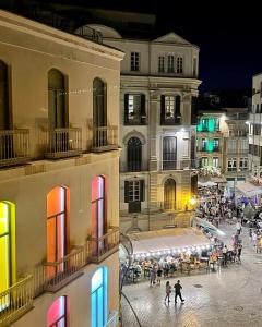 Cool home Malaga city center في مالقة: مجموعة من الناس يتجولون في المدينة ليلا