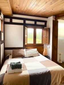 Un dormitorio con una cama grande en una habitación con techos de madera. en Casita rústica en Cambre