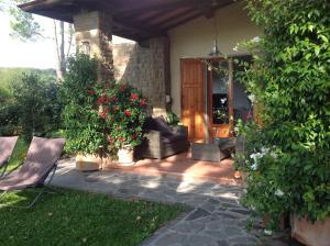 un patio con un sofá, una silla y flores en Da Ronald ... A Pian Del Papa, en Pratovecchio