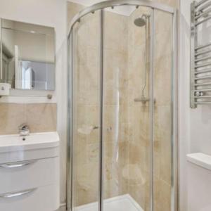 a shower with a glass door in a bathroom at Filey Bay Beach House Holiday Home The Bay Filey in Filey