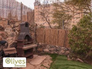 a backyard with a brick fence and an outdoor grill at Olives sweets in Arad