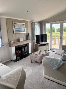 a living room with two couches and a television at Edmonton Lodge in West Bradford