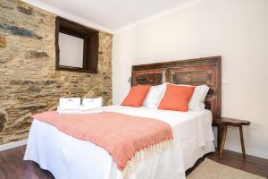 a bedroom with a large bed with orange pillows at Casa do Fincão in Bragança