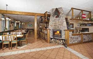 a restaurant with a fireplace in the dining room at Wellness Hotel Marlin in Nová Pec