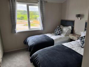 West BradfordにあるEdmonton Lodgeのベッド2台と窓が備わるホテルルームです。