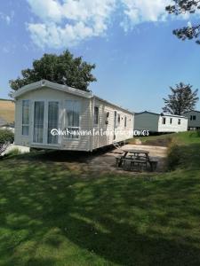 ein winziges Haus mit einem Picknicktisch im Hof in der Unterkunft Hakuna Matata Holiday Homes - Newquay Bay Resort in Newquay