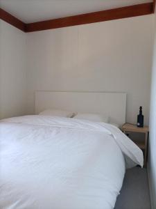 een slaapkamer met een wit bed en een houten hoofdeinde bij Quinta da Sonia, Melides in Melides