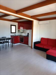 een woonkamer met een rode bank en een tafel bij Quinta da Sonia, Melides in Melides