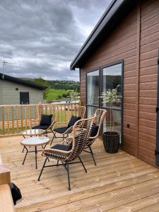 a wooden deck with chairs and a table on it at Edmonton Lodge in West Bradford