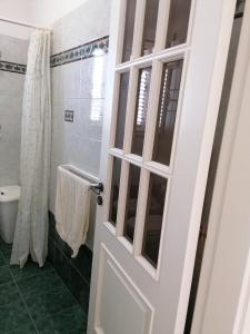 a bathroom with a white door and a shower at Villetta Lido Marini in Lido Marini