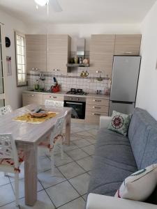 a kitchen with a table and a couch in a room at Villetta Lido Marini in Lido Marini