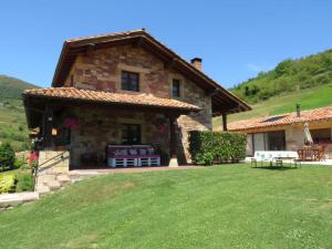 a stone house with a lawn in front of it at Casa Cordancas in Cicera