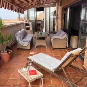 patio z krzesłami, stołem i kanapą w obiekcie Luxury Atico Granada Coast w mieście Motril