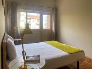 - une chambre avec un lit et une table avec une lampe dans l'établissement Convenient 3-Bedroom Apartments next to Bom Sucesso, à Porto