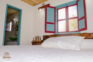 a bedroom with a white bed and a window at HOTEL COLONIAL VILLA CARMELA in Tota