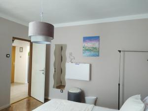 a bedroom with a bed and a pendant light at Alba Opatija in Opatija