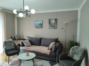 uma sala de estar com um sofá e duas cadeiras em Alba Opatija em Opatija