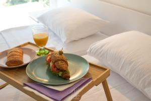 a table with a sandwich and a glass of orange juice at Pansion Hukić B&B in Tuzla